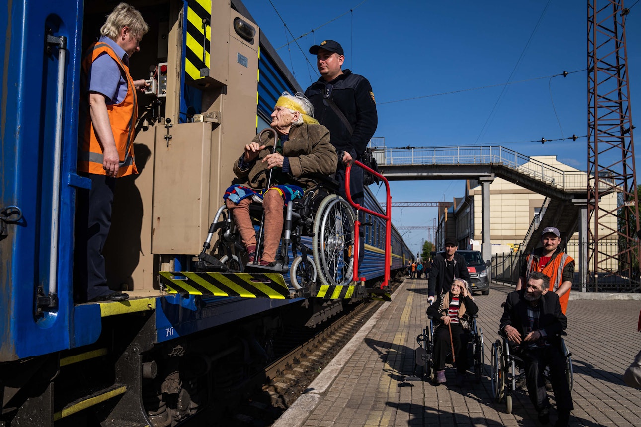 Рятувальник допомагає літній жінці з інвалідністю сісти на евакуаційний потяг. Покровськ, 26 квітня 2022 року.