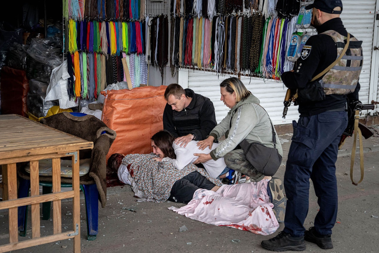 Сабіна плаче над тілом її чоловіка Артема Погорілця, який загинув після атаки росіян на ринок Барабашово. Харків, 21 липня 2022 року.